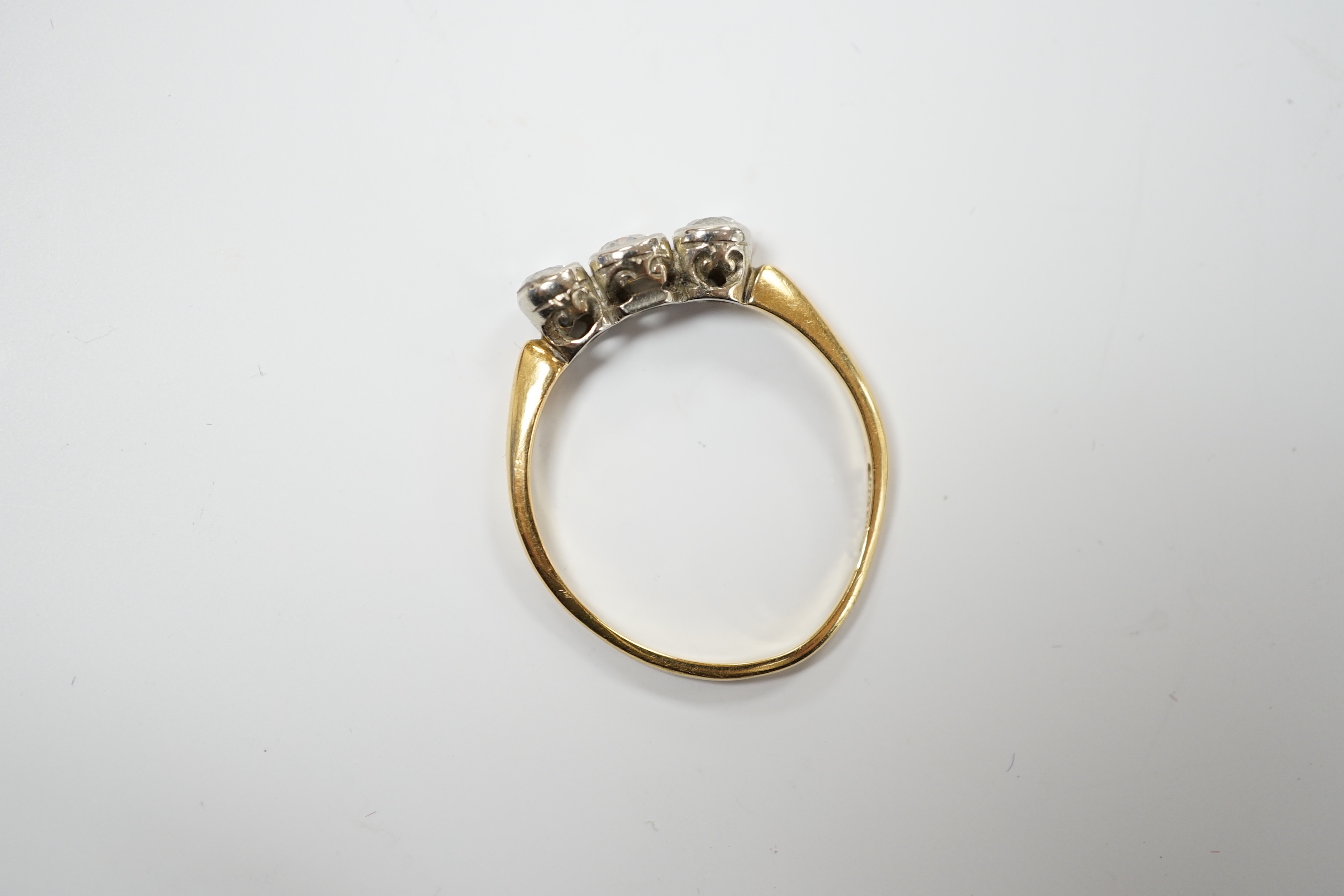 An 18ct and collet set three stone diamond ring, size R, gross weight 2.6 grams.